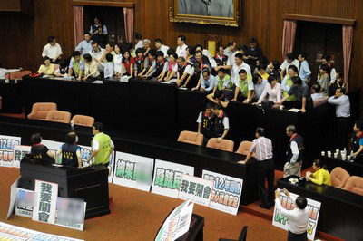 台“立法院”25日召开第3会期临时会第2次会议,国民党及民进党“立委”一早便占据主席台,两党“立委”在主席台上拉扯。图片来源:台湾“中央社”