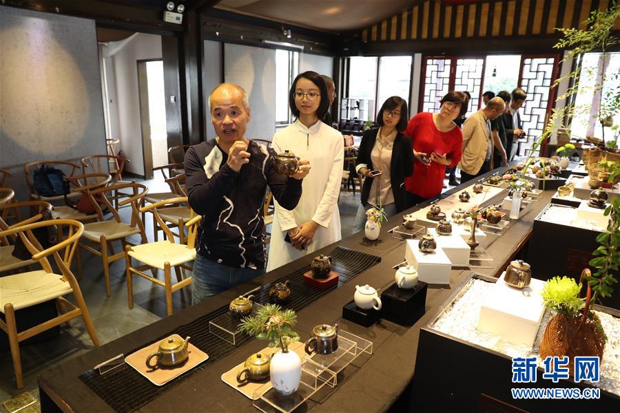 11月18日，在福州舉行的兩岸柴燒陶藝茶器交流展上，台灣陶藝師陳金旺（左一）在向參觀者介紹自己的柴燒茶器作品。