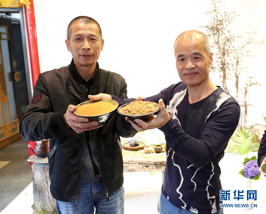 11月18日，在福州舉行的兩岸柴燒陶藝茶器交流展上，台灣陶藝師陳金旺（右）與福建陶藝師陳艗互換制陶紅土。