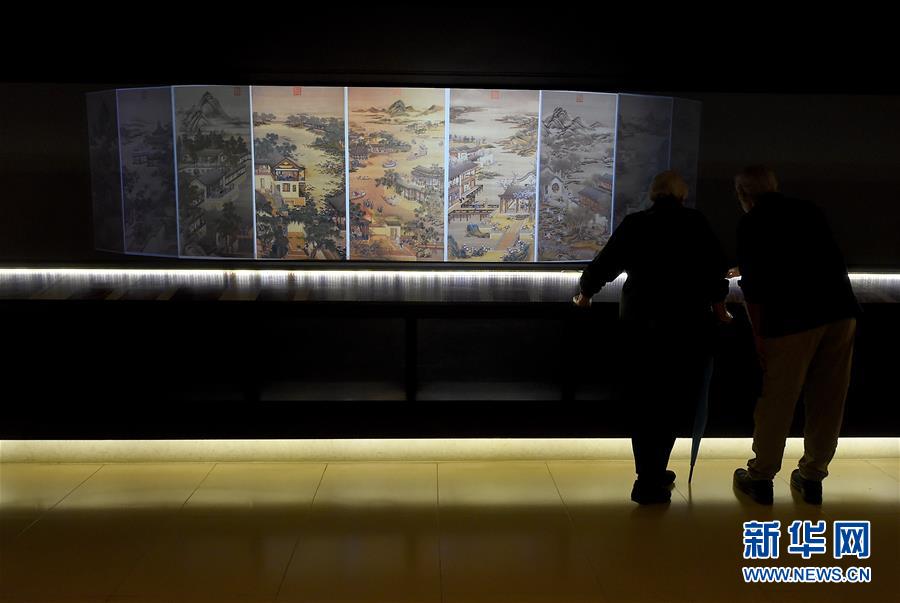1月8日，兩名游客在台北故宮博物院欣賞《十二月令圖》的動漫。