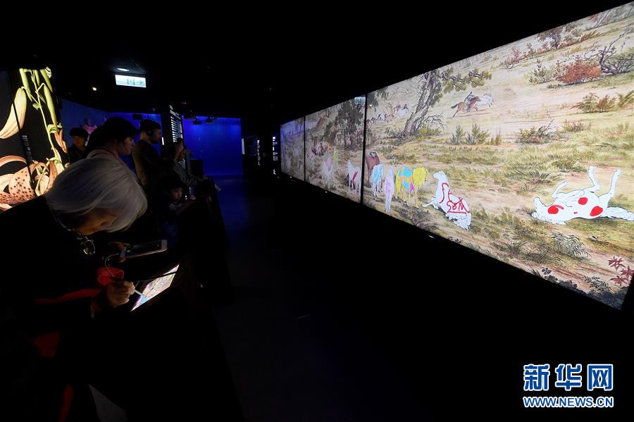1月8日，在台北故宮博物院郎世寧新媒體藝術展上，游客在平板電腦上為《百駿圖》中的馬匹涂色。