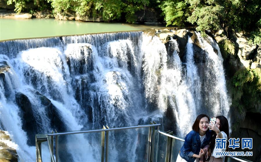1月14日，兩名游客在新北市十分瀑布前拍照。