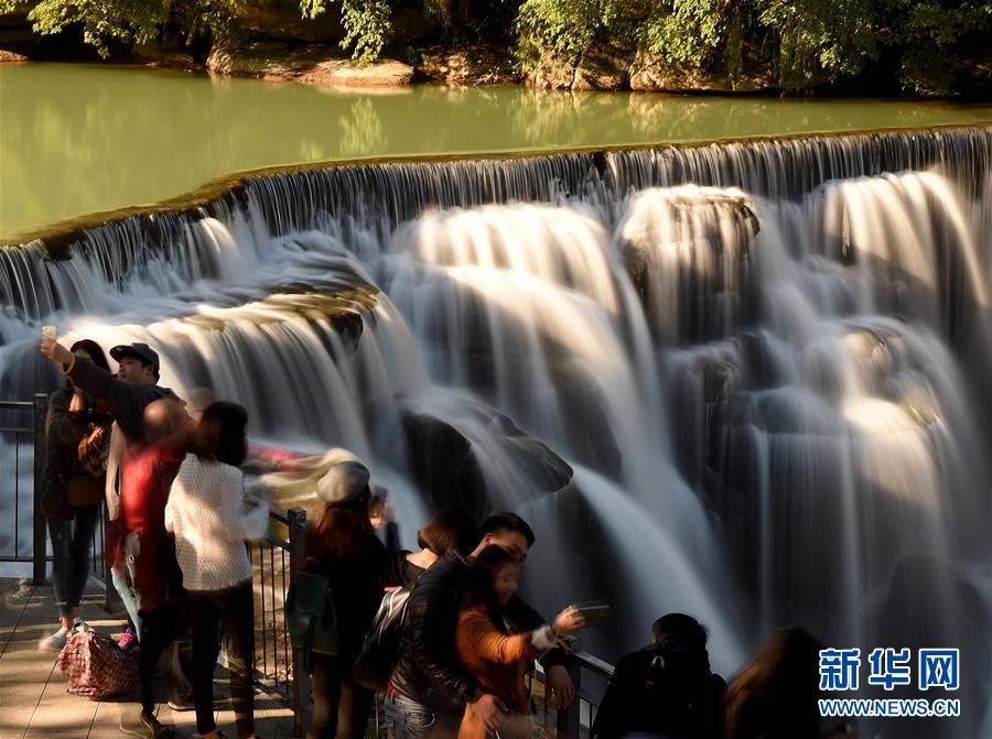 1月14日，游客在新北市十分瀑布邊游玩。