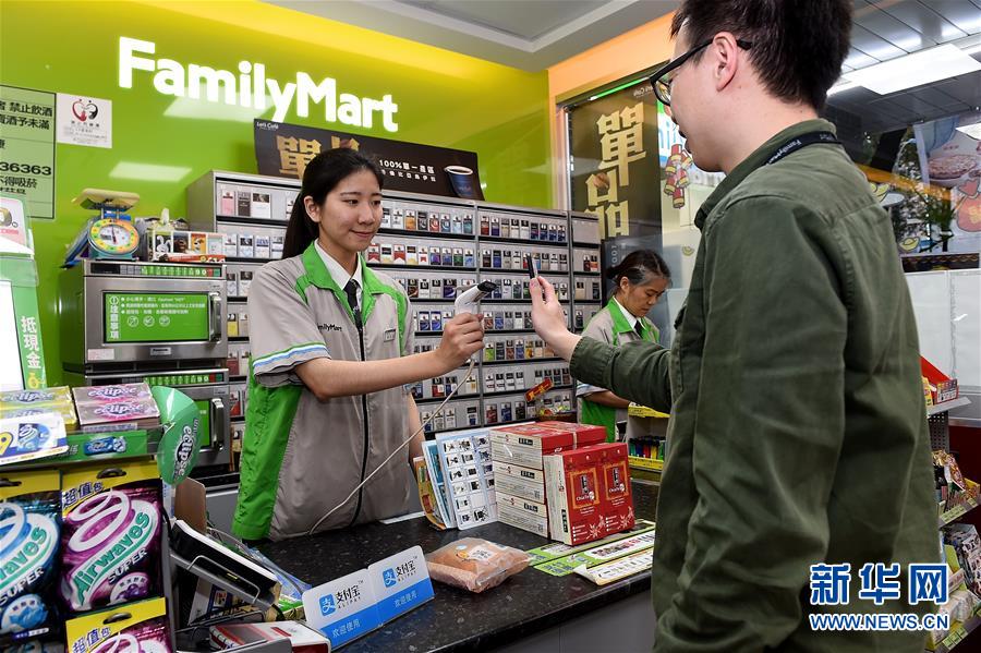 1月19日，一名顧客（右）在超市使用支付寶購物。