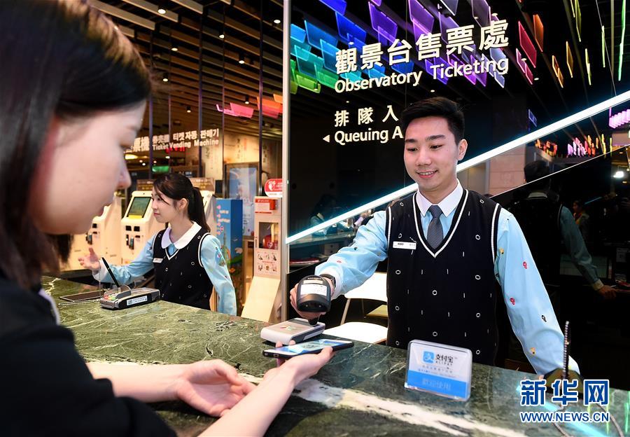 1月19日，一名游客（左）使用支付寶購買台北101大樓門票。