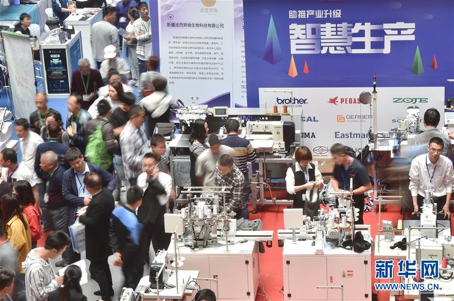 4月18日，客商在博覽會上了解自動化紡織設備。