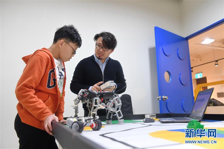徐國峰（右）教學生方奕翔設計機器人運動程序（3月27日攝）。