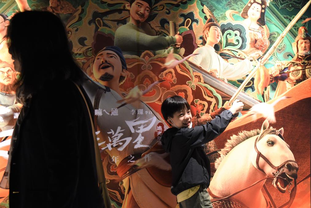 4月28日，观众在电影海报前拍照。新华社记者 刘斐 摄