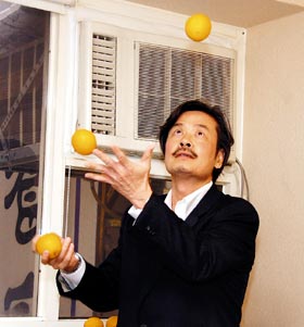 卸下国民党秘书长职务,金溥聪显得格外神清气爽,他兑现承诺,在媒体面前表演抛接三颗橙子的技艺。图片来源:台湾《联合报》