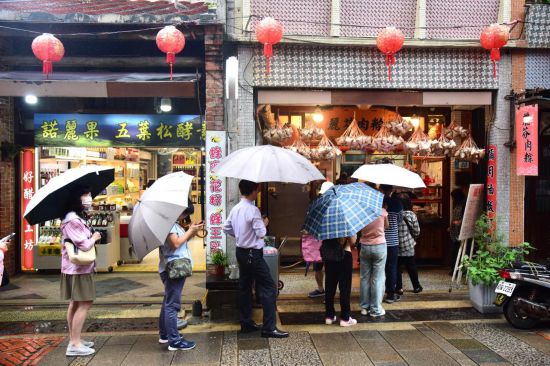 　　在新北深坑老街的一家肉粽店门外，人们排队购买粽子（6月6日摄）。新华社记者 王承昊 摄