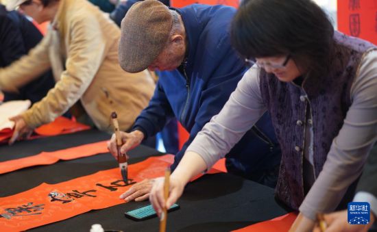 2月6日，在首届“台湾汉纸两岸艺术家春联、年画、漫画展”现场，参展艺术家书写春联。新华社记者 黄扬 摄